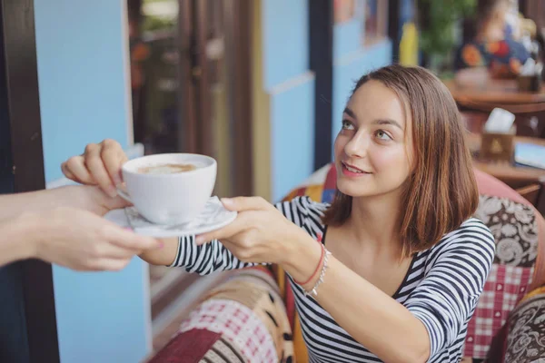 Giovane donna seduta al coperto in un caffè urbano — Foto Stock