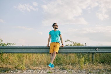 Gülümseyen ve güneşli yaz günü zevk genç adam