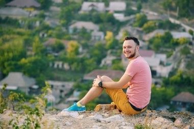 Gülümseyen ve güneşli yaz günü zevk genç adam