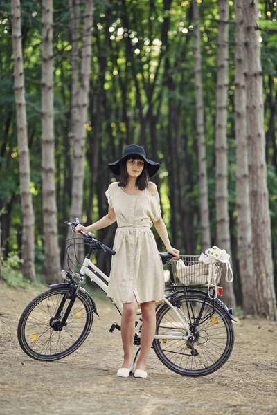 Молода жінка на фоні природи з велосипедом — стокове фото