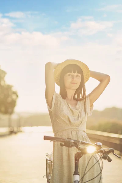 Jovem mulher contra a natureza fundo com bicicleta — Fotografia de Stock