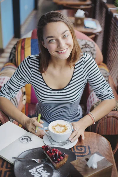 Młoda kobieta siedząca kryty w kawiarni miejskiej — Zdjęcie stockowe
