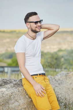 Gülümseyen ve güneşli yaz günü zevk genç adam
