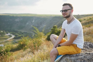 Gülümseyen ve güneşli yaz günü zevk genç adam