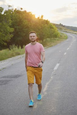 Gülümseyen ve güneşli yaz günü zevk genç adam