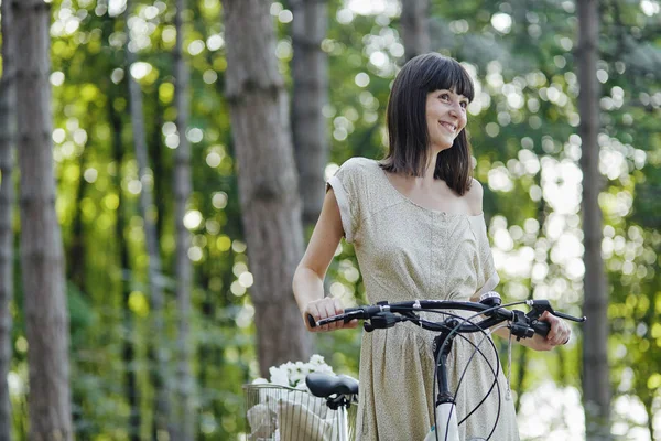 Молодая женщина на фоне природы с велосипедом — стоковое фото