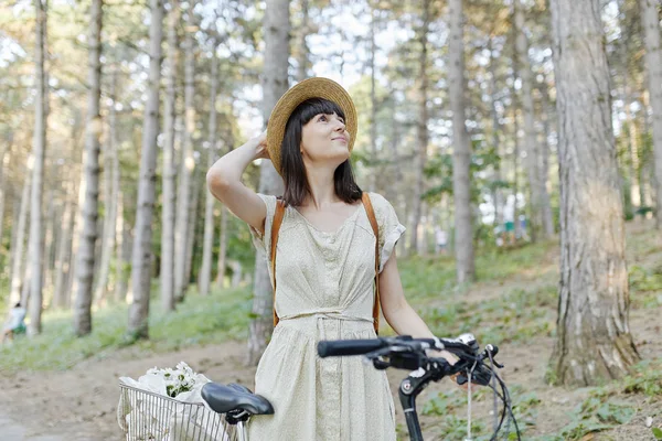 Jovem mulher contra a natureza fundo com bicicleta — Fotografia de Stock