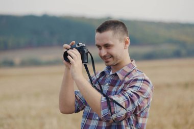 Açık havada gün batımında çekici erkek fotoğrafçı