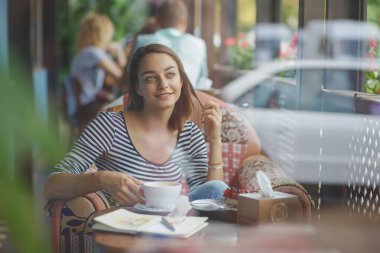 kapalı kentsel cafede oturan genç kadın