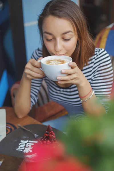 Ung kvinna sitter inomhus i urban café — Stockfoto