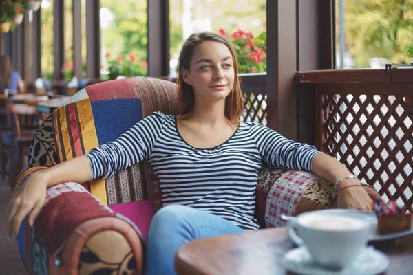 Mujer joven sentada en el interior de un café urbano — Foto de Stock