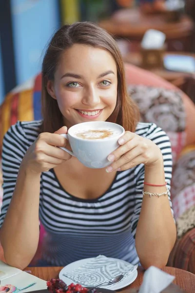 Jonge vrouw zitten binnen in stedelijke café — Stockfoto