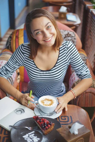 Jonge vrouw zitten binnen in stedelijke café — Stockfoto