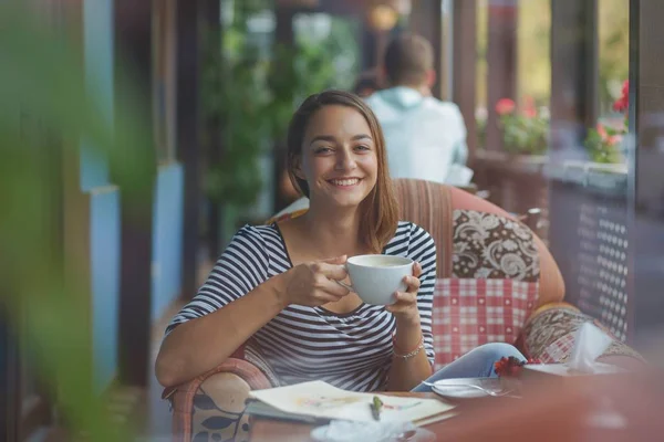 Jonge vrouw zitten binnen in stedelijke café — Stockfoto