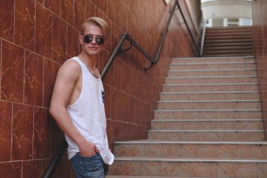 Hipster sarışın yakışıklı adam sokakta şık yaz giysileri