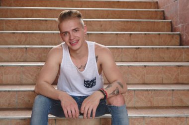 Hipster sarışın yakışıklı adam sokakta şık yaz giysileri