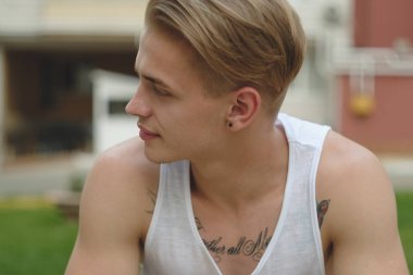 Hipster sarışın yakışıklı adam sokakta şık yaz giysileri