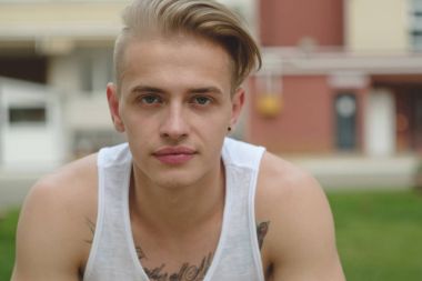 Hipster sarışın yakışıklı adam sokakta şık yaz giysileri