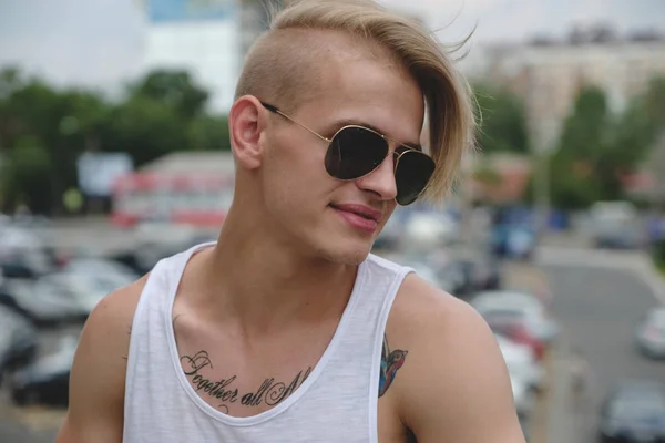 Hipster knappe blonde man man in stijlvolle zomer kleding in de straat — Stockfoto