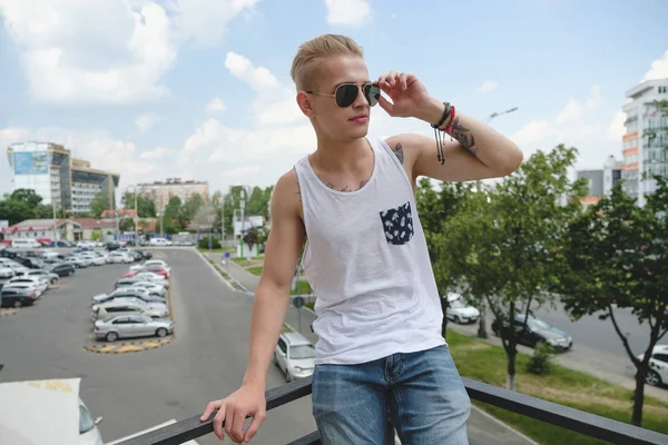 Hipster handsome blonde man guy in stylish summer clothes in the street — Stock Photo, Image