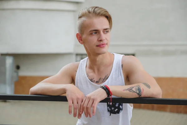 Hipster handsome blonde man guy in stylish summer clothes in the street