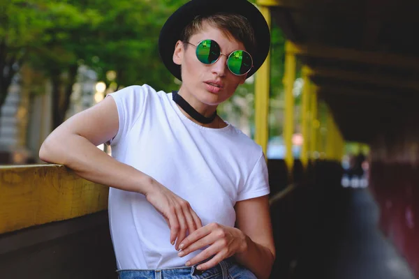 Retrato de hipster femenino con maquillaje natural y corte de pelo corto disfrutando de tiempo libre al aire libre — Foto de Stock