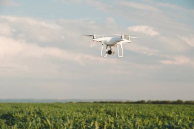 Beyaz dron açık mavi gökyüzünde süzülüyor