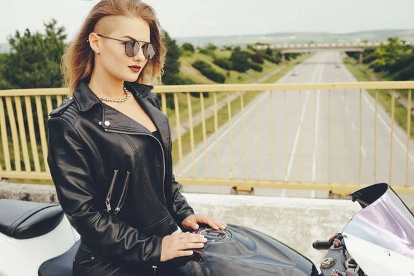 Chica motociclista en una ropa de cuero en una motocicleta —  Fotos de Stock