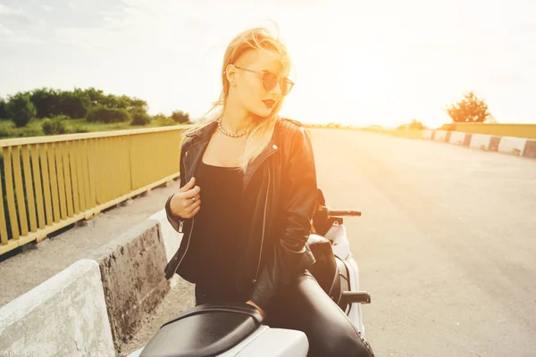 Biker meisje in een lederen kleding op een motorfiets — Stockfoto