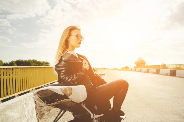 Biker meisje in een lederen kleding op een motorfiets — Stockfoto