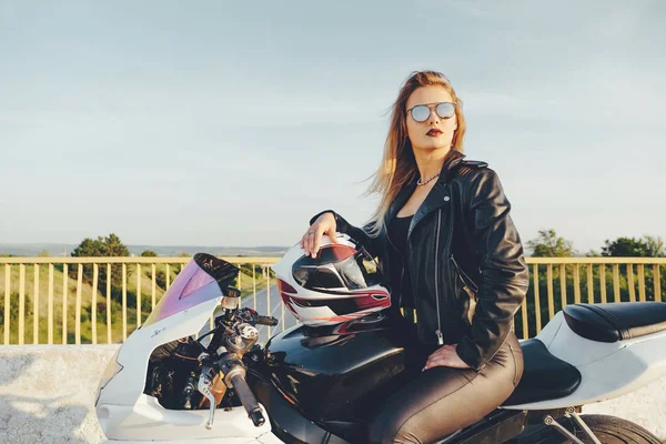 Biker pige i læder tøj på en motorcykel - Stock-foto