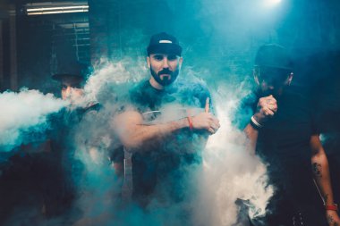 Tuğla duvarlı otantik bir odada üç kişi vaping