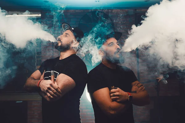 İki adam vaping tuğla duvarlı otantik bir odada