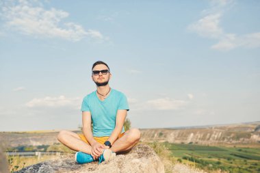 Gülümseyen ve güneşli yaz günü zevk genç adam