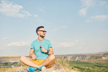 Gülümseyen ve güneşli yaz günü zevk genç adam