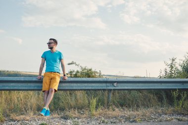 Gülümseyen ve güneşli yaz günü zevk genç adam