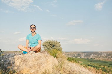 Gülümseyen ve güneşli yaz günü zevk genç adam