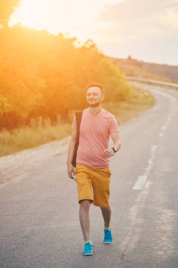 Gülümseyen ve güneşli yaz günü zevk genç adam