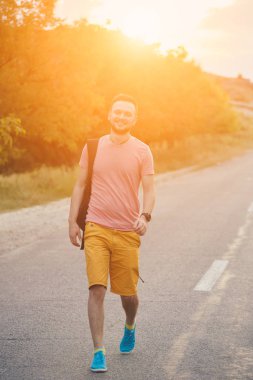 Gülümseyen ve güneşli yaz günü zevk genç adam