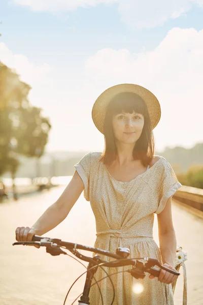 На відкритому повітрі портрет привабливої молодої брюнетки в капелюсі на велосипеді . — стокове фото