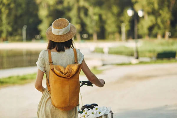 Ritratto all'aperto di giovane bruna attraente in un cappello su una bicicletta . — Foto Stock