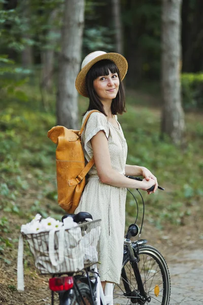 자전거에 모자에 매력적인 젊은 갈색 머리의 야외 초상화. — 스톡 사진