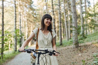 Çekici genç esmer bir bisiklet üzerinde açık portresi.
