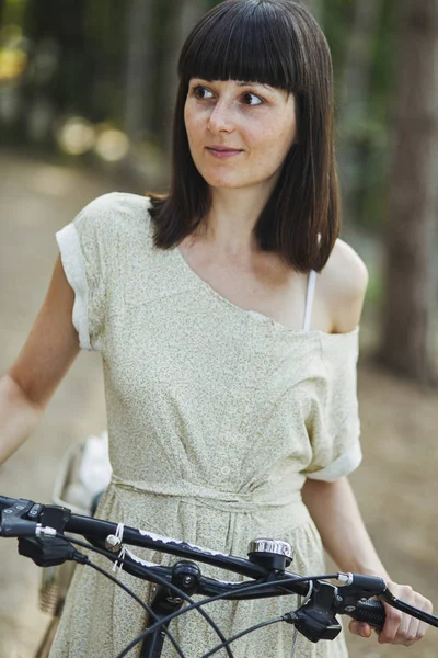 На відкритому повітрі портрет привабливої молодої брюнетки на велосипеді . — стокове фото