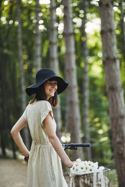 Açık bir bisiklet üzerinde şapkalı çekici genç esmer portresi. — Stok fotoğraf