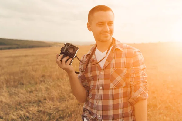 Привабливий чоловічий фотограф на свіжому повітрі під час заходу сонця — стокове фото