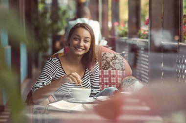 kapalı kentsel cafede oturan genç kadın