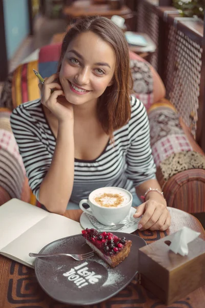 Junge Frau sitzt drinnen in urbanem Café — Stockfoto