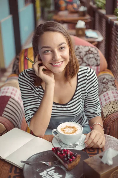Jeune femme assise à l'intérieur dans un café urbain — Photo