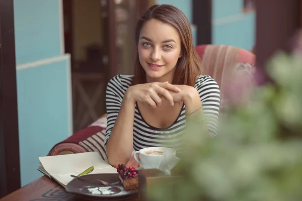 Jonge vrouw zitten binnen in stedelijke café — Stockfoto